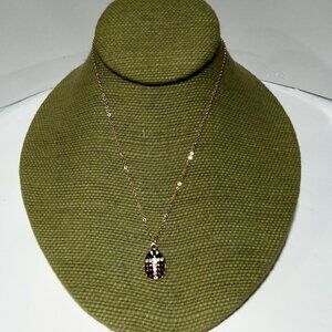 Women`s gold tone lady bug crystal necklace.